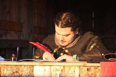Zephaniah of Felix's Watch Banner carefully recording important events at the King's Stoke Wassail