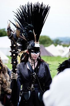 A traditional tunic, and drab colours, mark this as Kallavesi even without to painting around the eyes and the feathered head dress.